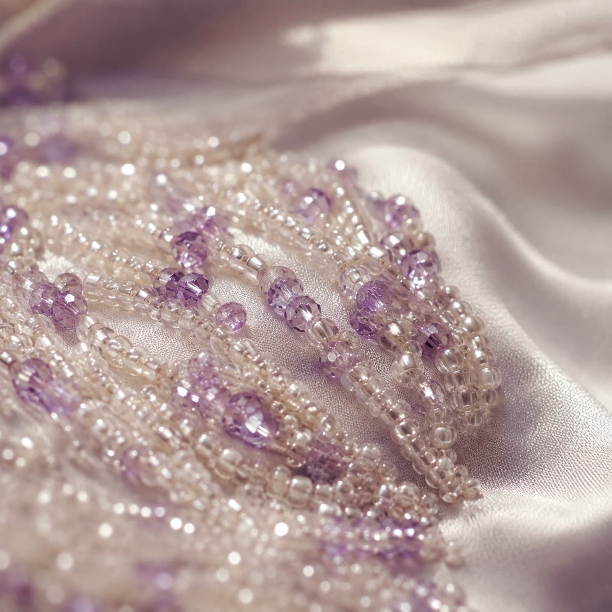 Macro photograph of glass beading worked over satin
