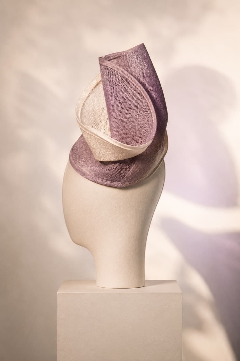 Layered couture fascinator on a featureless display block